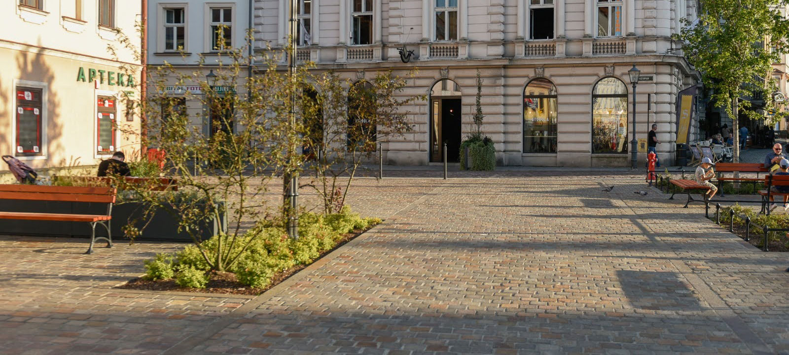 Porphyry paving across a sunlit historic streetscape